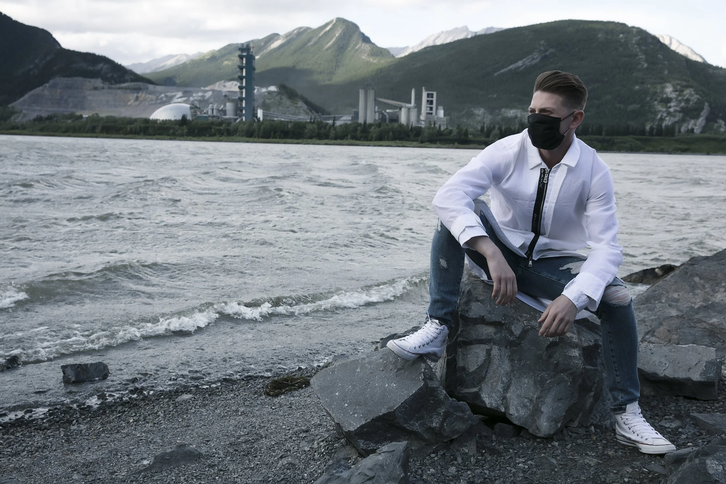 Benjamin Wills in a sleeveless black hooded look posed against mountain skies.