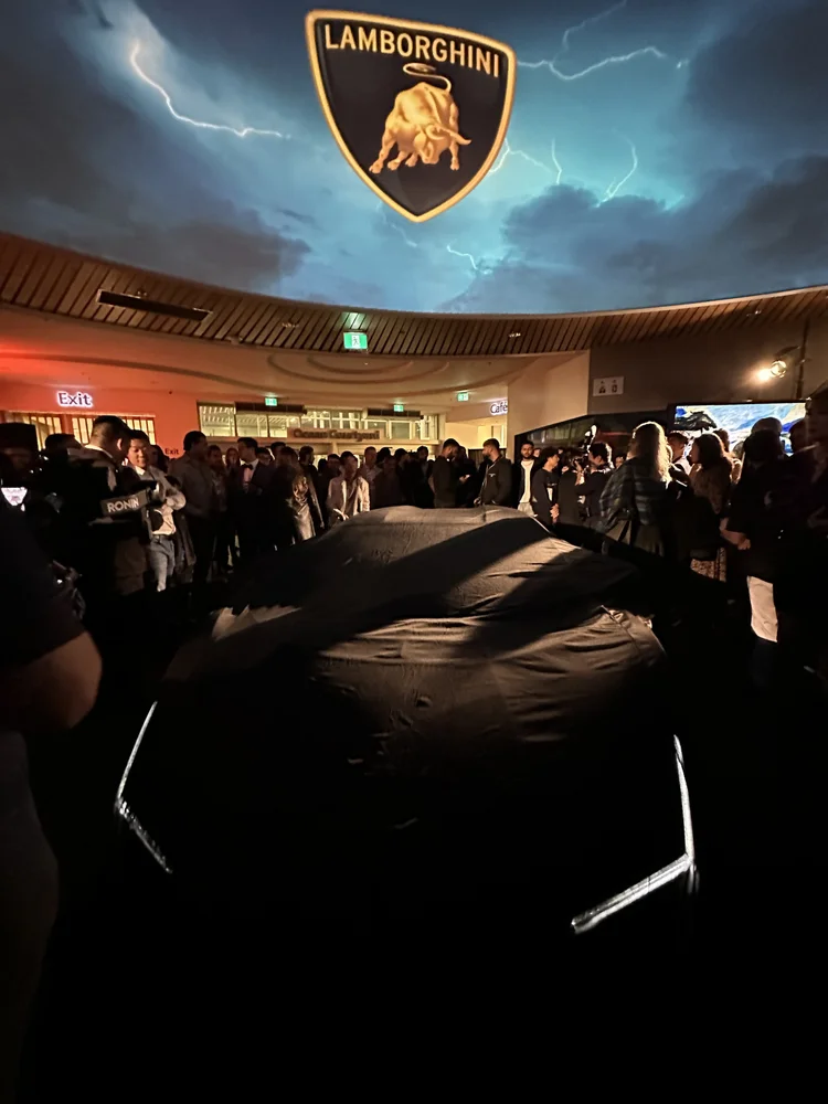 A Lamborghini reveal event with Benjamin Wills present among the crowd.