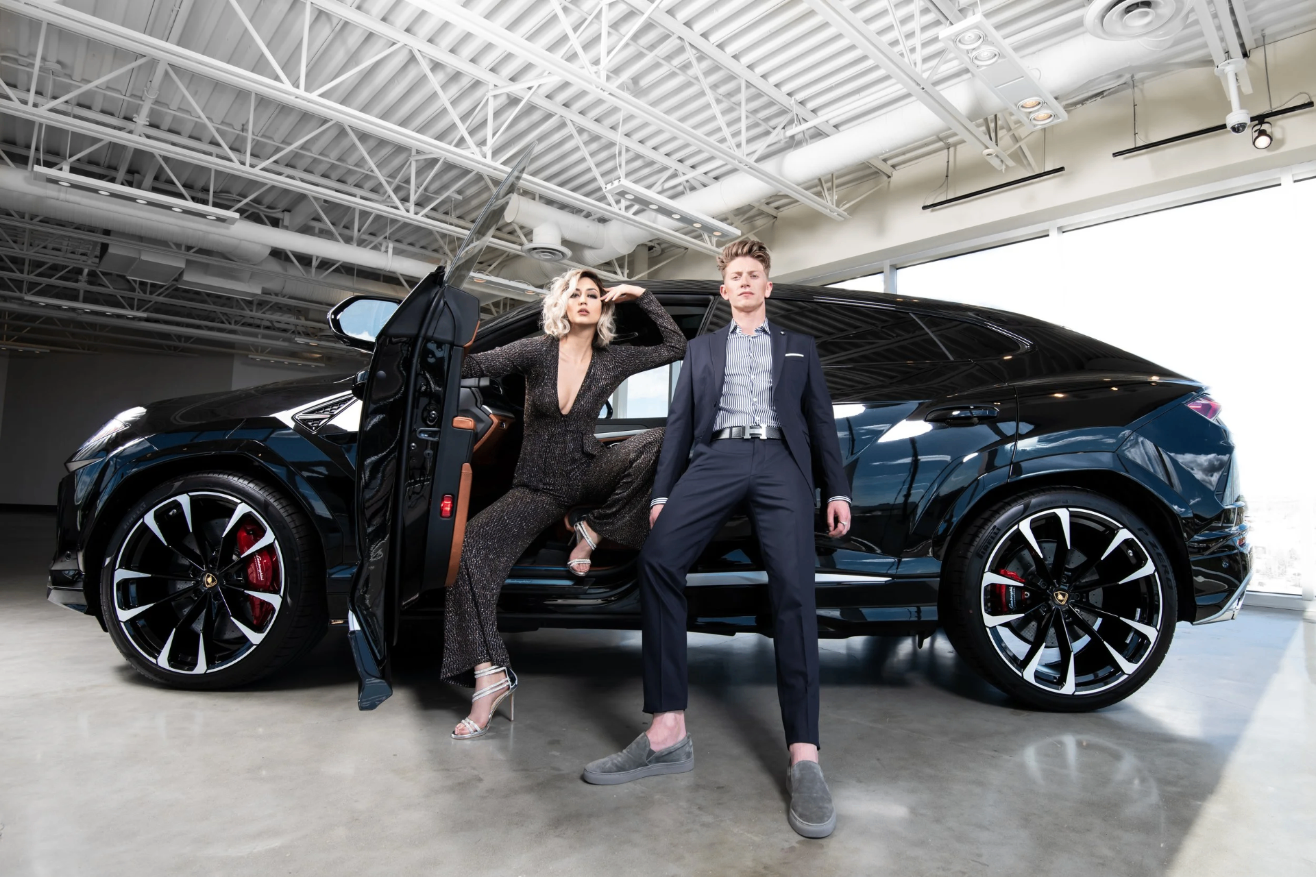 Benjamin Wills and a model posed with a black Lamborghini in an editorial setting.